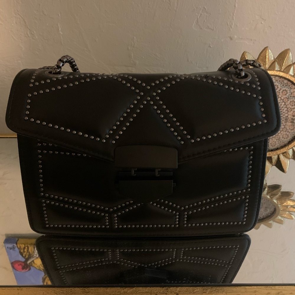 Black purse with adjustable strap.